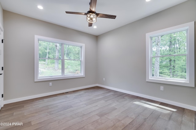 spare room featuring light hardwood / wood-style floors, plenty of natural light, and ceiling fan