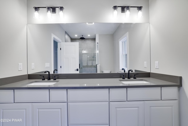 bathroom with vanity, toilet, and a shower with shower door