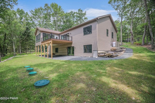 rear view of house featuring a yard, a deck, and a patio area