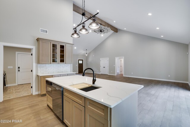 kitchen with dishwasher, high vaulted ceiling, a center island with sink, sink, and beam ceiling