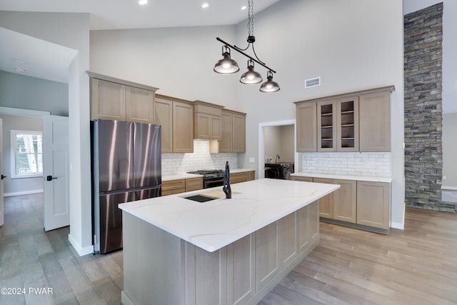 kitchen with stainless steel fridge, sink, backsplash, and high vaulted ceiling