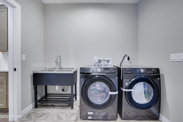 washroom with washer and dryer and sink