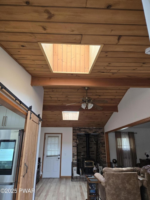 100 Saddlebrook Ln, Lords Valley, PA 18428 - living room featuring a wood stove, light wood-style floors, vaulted ceiling, wooden ceiling, and a barn door