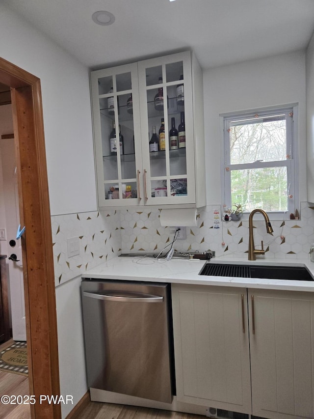 100 Saddlebrook Ln, Lords Valley, PA 18428 - bar featuring stainless steel dishwasher, a sink, tasteful backsplash, and light wood-type flooring