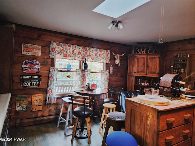 kitchen with hardwood / wood-style flooring, a skylight, and wooden walls