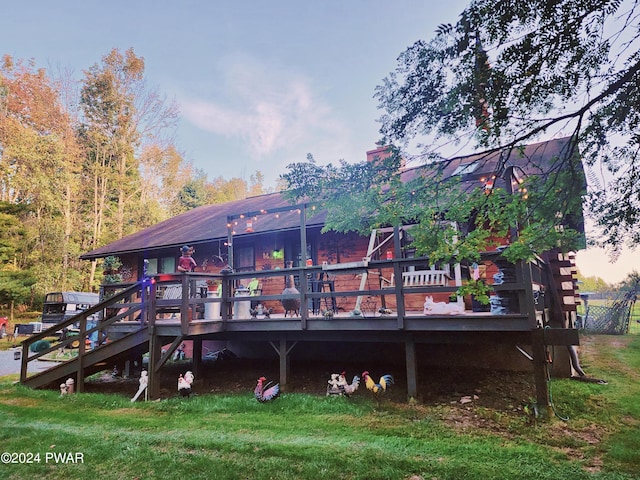 back house at dusk with a yard and a wooden deck