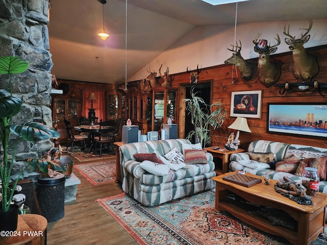 living room with wood walls, hardwood / wood-style floors, and vaulted ceiling