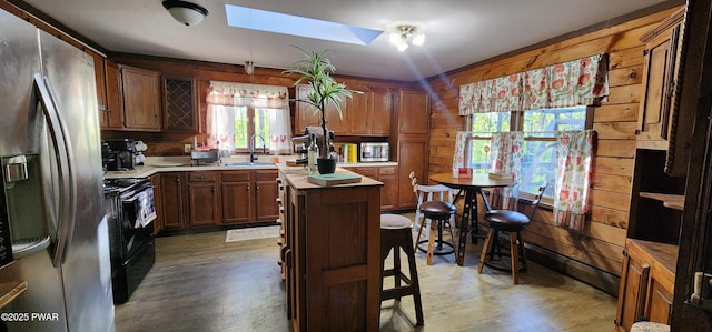 145 Father John Dr, Lake Ariel, PA 18436 - kitchen with stainless steel fridge, black / electric stove, a sink, a skylight, and wood finished floors