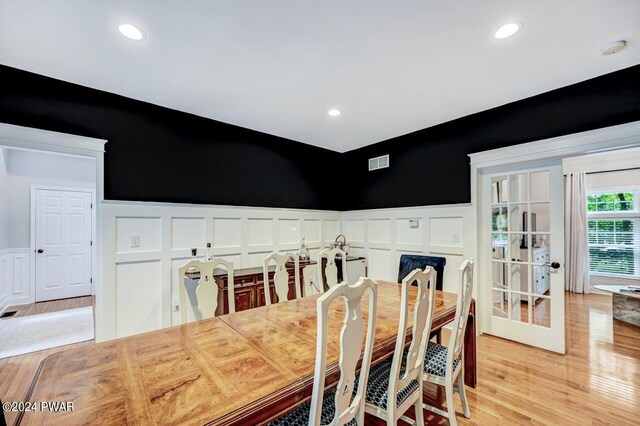 dining space with french doors and light hardwood / wood-style floors