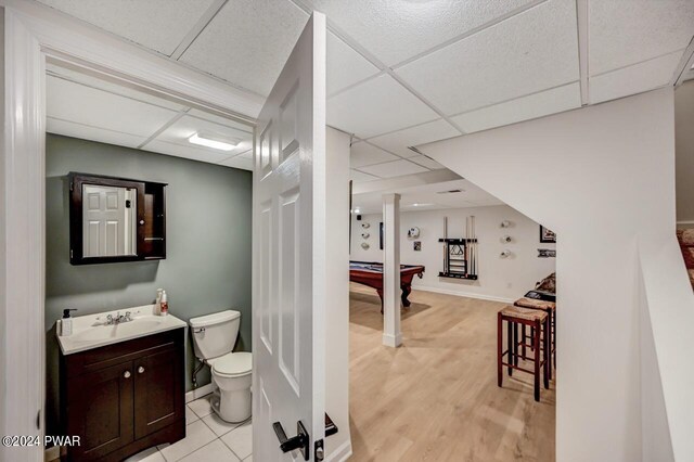 bathroom with vanity, toilet, a drop ceiling, and billiards