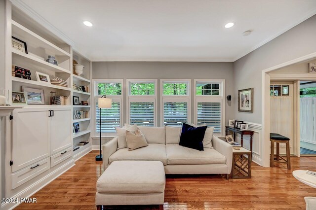 living room with light wood-type flooring and ornamental molding