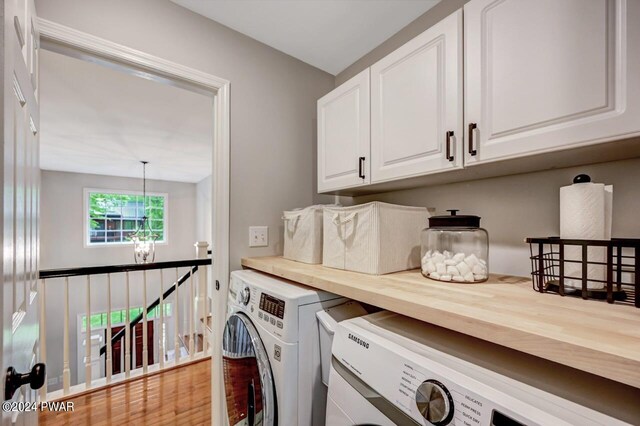 clothes washing area featuring washer and dryer and cabinets