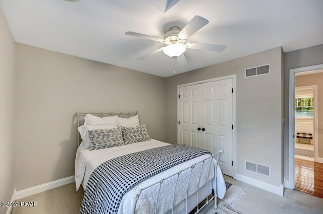 bedroom with light colored carpet, a closet, and ceiling fan