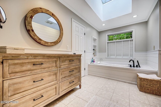 bathroom with a skylight, a washtub, tile patterned flooring, and ornamental molding