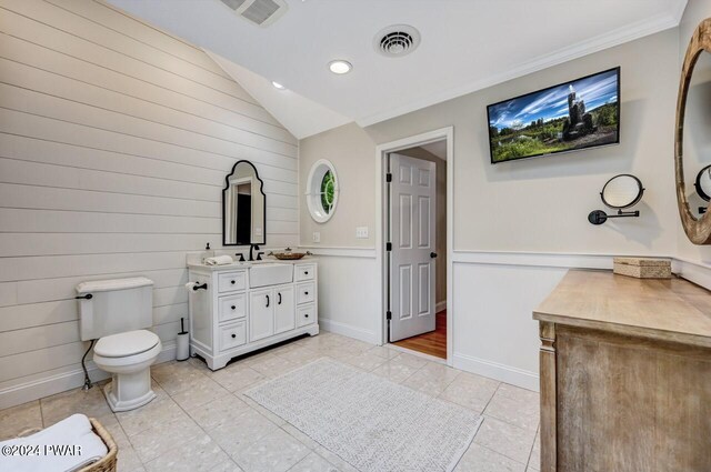 bathroom featuring tile patterned floors, vanity, toilet, and vaulted ceiling