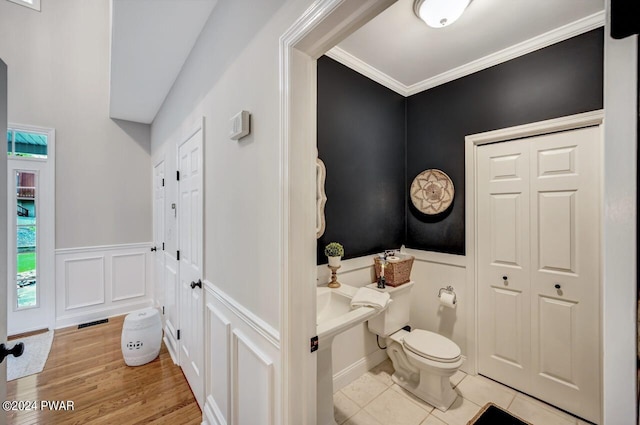 bathroom with tile patterned floors, toilet, and ornamental molding