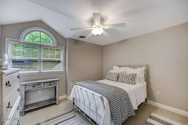 bedroom featuring ceiling fan, light colored carpet, and vaulted ceiling