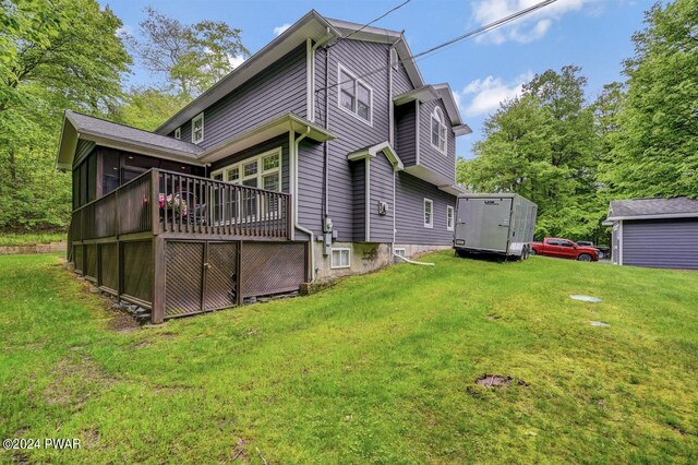 rear view of house with a deck and a yard