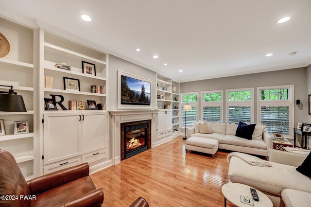 living room with built in features and light wood-type flooring