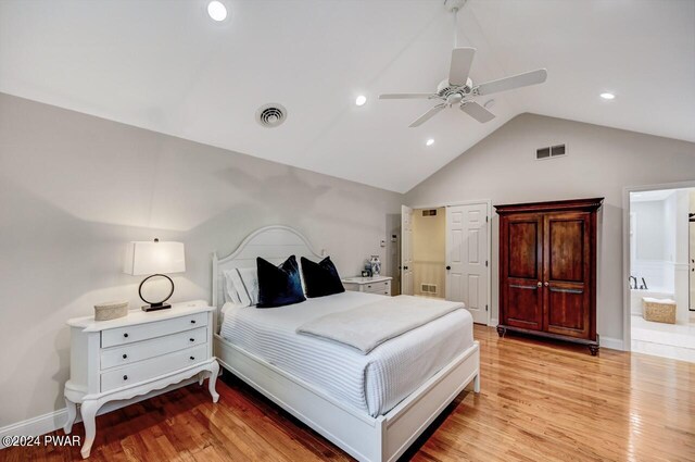 bedroom with ensuite bathroom, vaulted ceiling, ceiling fan, and light hardwood / wood-style flooring