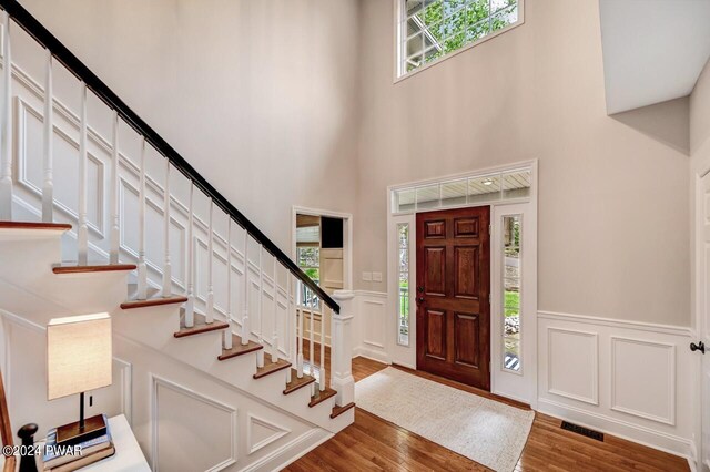 foyer featuring wood-type flooring and a high ceiling