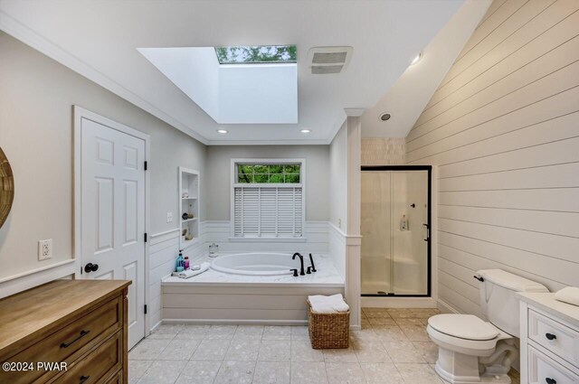 full bathroom featuring a skylight, toilet, vanity, and shower with separate bathtub