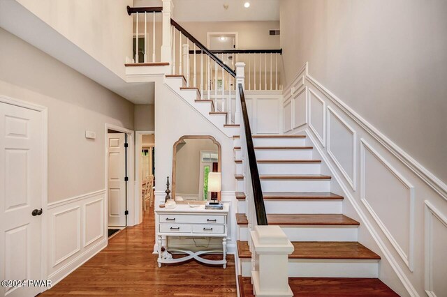 stairway featuring hardwood / wood-style flooring and a high ceiling