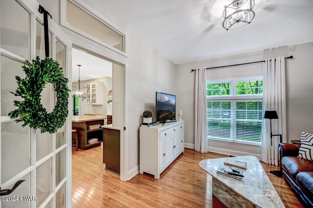 living room featuring a chandelier and light wood-type flooring