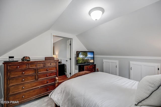 carpeted bedroom with lofted ceiling