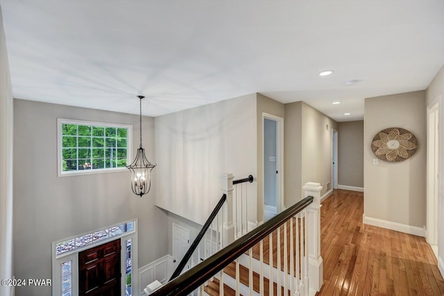 hallway featuring a notable chandelier and wood-type flooring