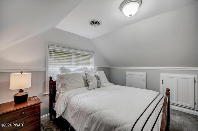 bedroom featuring dark carpet and vaulted ceiling