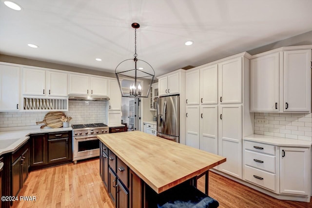 kitchen with appliances with stainless steel finishes, white cabinetry, and pendant lighting