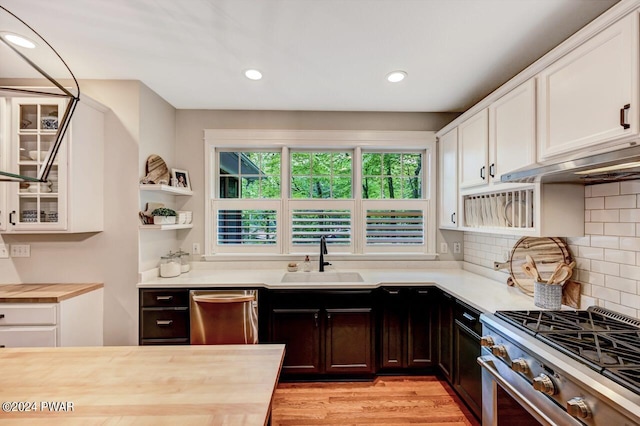 kitchen with white cabinets, appliances with stainless steel finishes, butcher block countertops, and sink