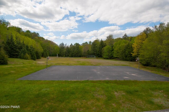 surrounding community featuring a yard and basketball court