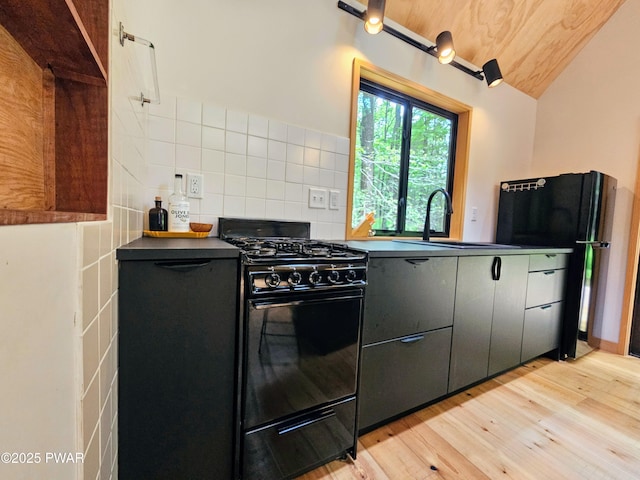 23 Highland Ln, Hawley, PA 18428 - kitchen featuring black appliances, light wood finished floors, dark countertops, tasteful backsplash, and lofted ceiling