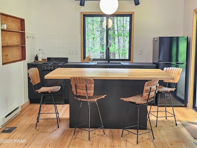 23 Highland Ln, Hawley, PA 18428 - kitchen with freestanding refrigerator, wood counters, black range with gas cooktop, light wood-style flooring, and baseboard heating