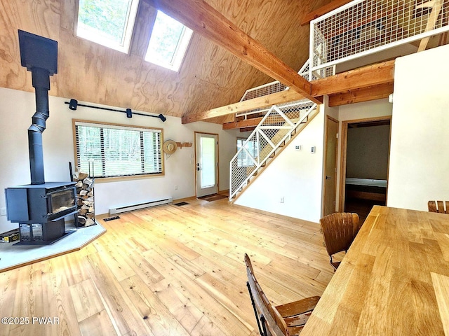23 Highland Ln, Hawley, PA 18428 - living room with baseboard heating, a wood stove, wood finished floors, stairs, and a skylight