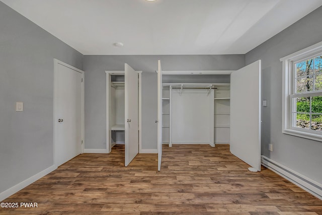 133 Neil Thompson Rd, Lackawaxen, PA 18435 - unfurnished bedroom with a baseboard radiator, wood finished floors, and two closets