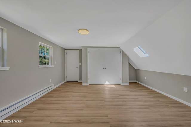133 Neil Thompson Rd, Lackawaxen, PA 18435 - additional living space with a baseboard heating unit, a skylight, light wood-type flooring, and vaulted ceiling