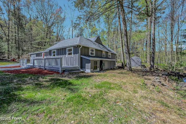 133 Neil Thompson Rd, Lackawaxen, PA 18435 - view of side of property with board and batten siding, a deck, and a yard