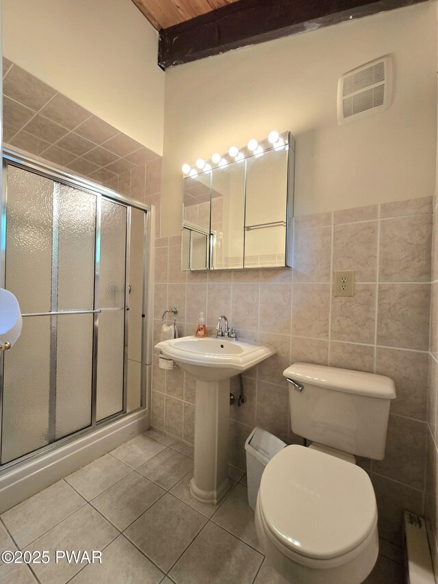 113 Widgeon Ln, Lords Valley, PA 18428 - bathroom with tile walls, a shower stall, tile patterned flooring, toilet, and a wainscoted wall