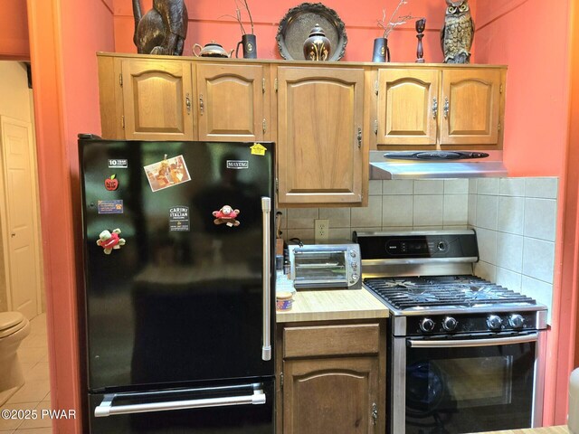 113 Widgeon Ln, Lords Valley, PA 18428 - kitchen with freestanding refrigerator, range with gas stovetop, under cabinet range hood, and backsplash