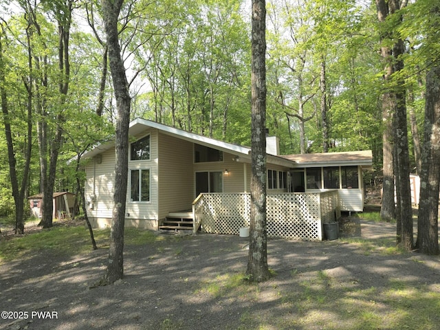 113 Widgeon Ln, Lords Valley, PA 18428 - back of property with a chimney, a sunroom, and a deck