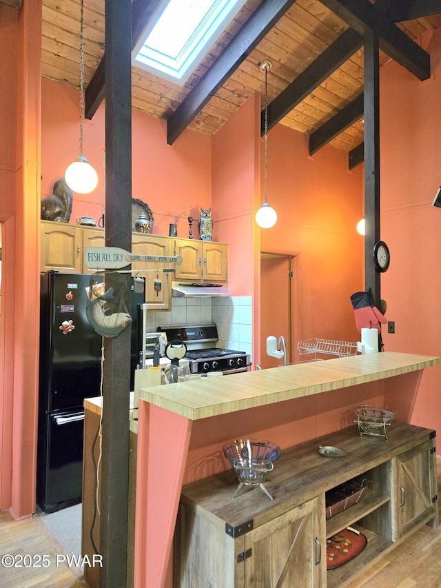 113 Widgeon Ln, Lords Valley, PA 18428 - kitchen featuring stainless steel gas stove, under cabinet range hood, a skylight, wooden ceiling, and freestanding refrigerator