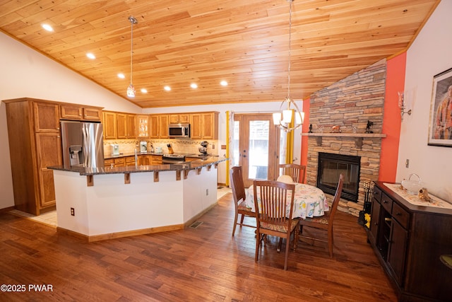 1010 Lotus Ter, Lake Ariel, PA 18436 - kitchen featuring vaulted ceiling, stainless steel appliances, wood ceiling, a kitchen bar, and wood finished floors