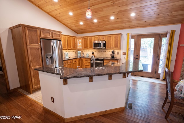1010 Lotus Ter, Lake Ariel, PA 18436 - kitchen featuring stainless steel appliances, wooden ceiling, brown cabinetry, vaulted ceiling, and a kitchen breakfast bar