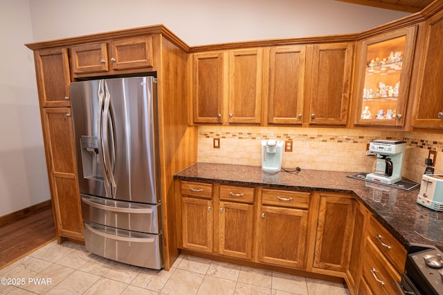 1010 Lotus Ter, Lake Ariel, PA 18436 - kitchen with stainless steel refrigerator with ice dispenser, brown cabinetry, backsplash, and dark stone counters