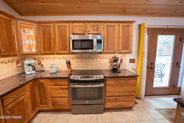 1010 Lotus Ter, Lake Ariel, PA 18436 - kitchen featuring appliances with stainless steel finishes, wood ceiling, brown cabinets, tasteful backsplash, and dark stone countertops