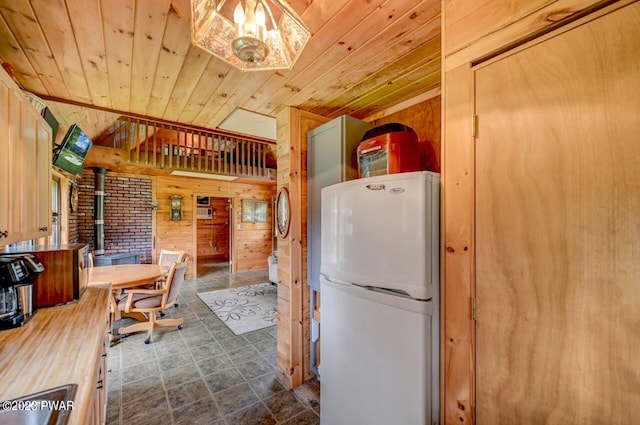 kitchen featuring white fridge, wood ceiling, and wooden walls