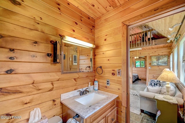 bathroom with vanity, wood ceiling, and wooden walls